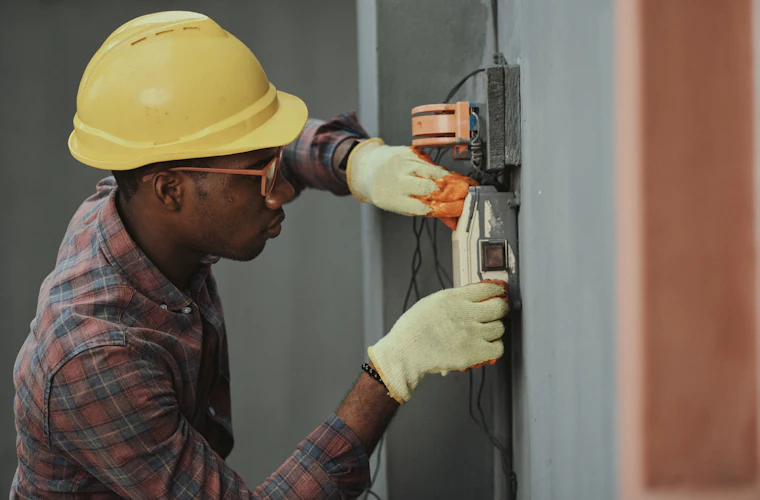 Licensed electrician testing a residential electrical box with a meter